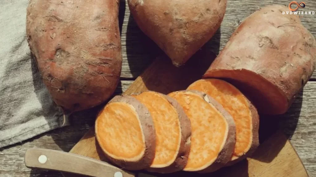 Sliced sweet potatoes on a wooden board, representing their long agricultural history and introduction to Texas.