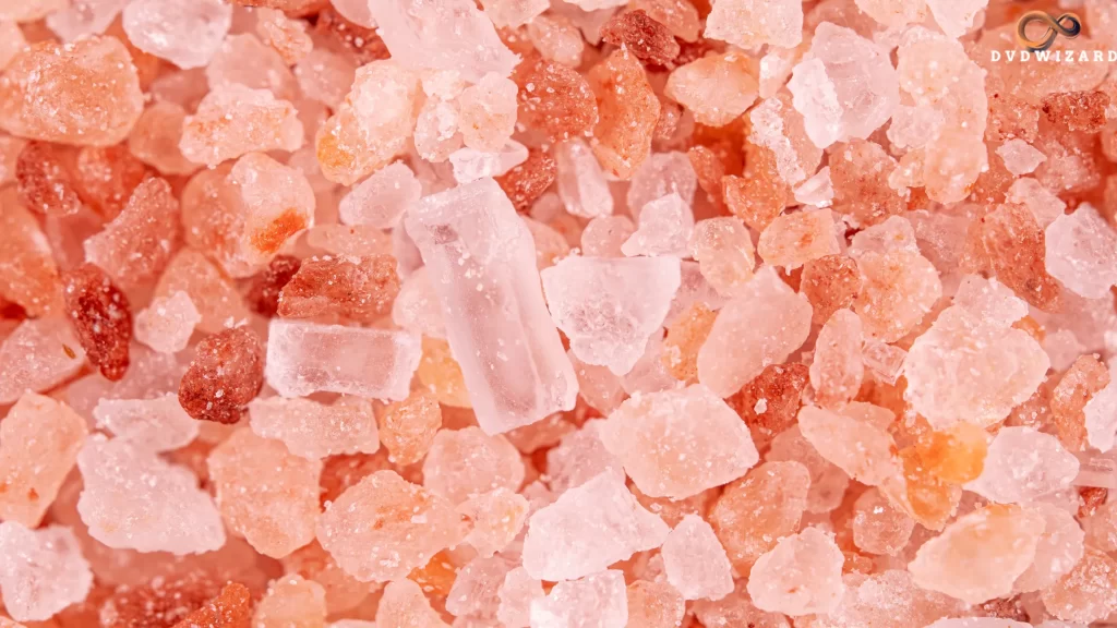 Close-up of pink Tibetan salt granules, highlighting their irregular shapes and mineral-rich texture.