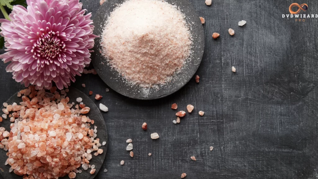 A rustic plate featuring coarse and fine pink Tibetan salt with a decorative flower.